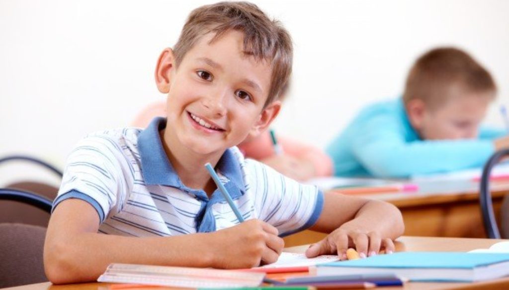Criança escrevendo em inglês, mostrando forte desenvolvimento infantil.