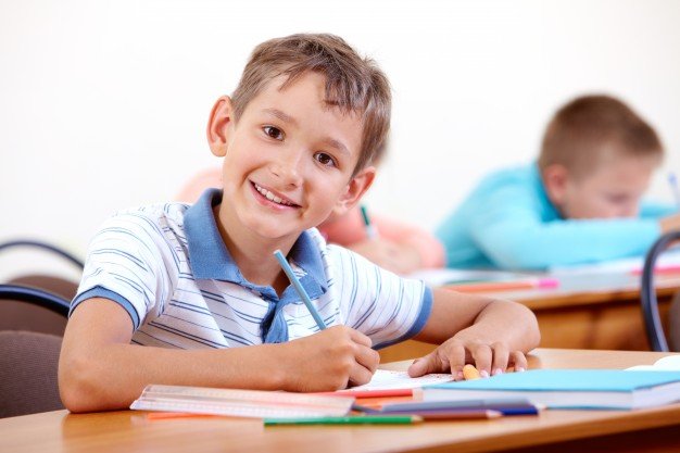 Criança escrevendo em inglês, mostrando forte desenvolvimento infantil.
