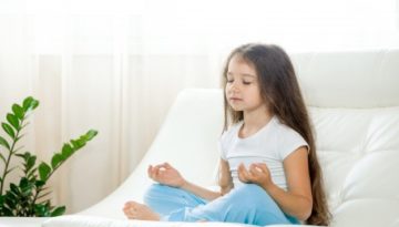 Criança meditando para diminuir indisciplina