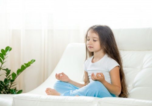 Criança meditando para aumentar disciplina escolar