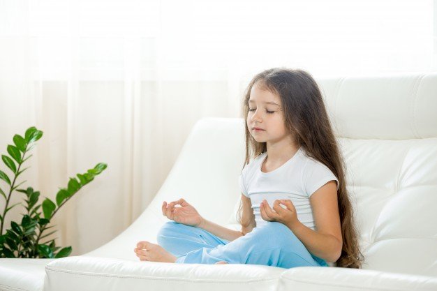 Criança meditando para aumentar disciplina escolar