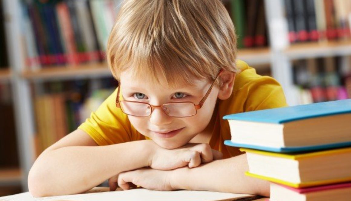 Criança sobre livros após aula. Escola mostrou como incentivar a leitura infantil aos pais.