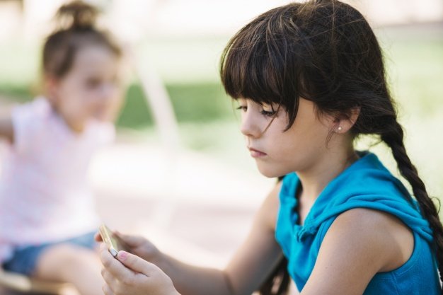 Criança com autismo jogando sozinha no recreio.