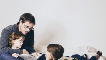 Pai lendo para os filhos após aula de como incentivar a leitura em casa