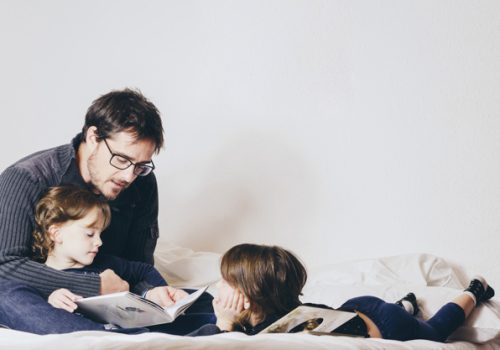 Pai lendo para os filhos após aula de como incentivar a leitura em casa