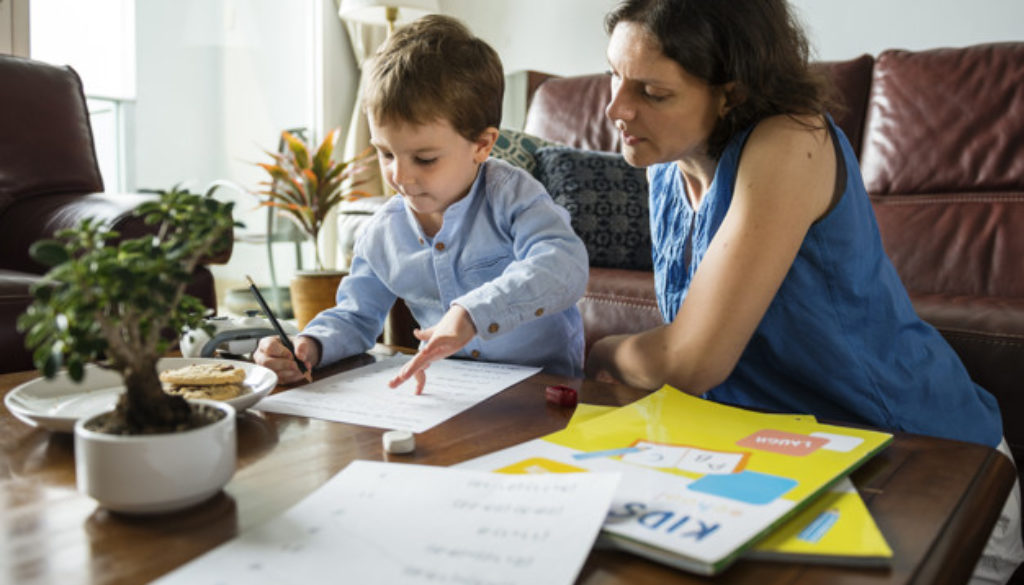 Mãe ensina o filho em casa, dentro da proposta educacional homeschooling.