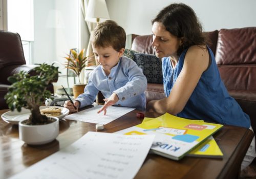 Mãe ensina o filho em casa, dentro da proposta educacional homeschooling.