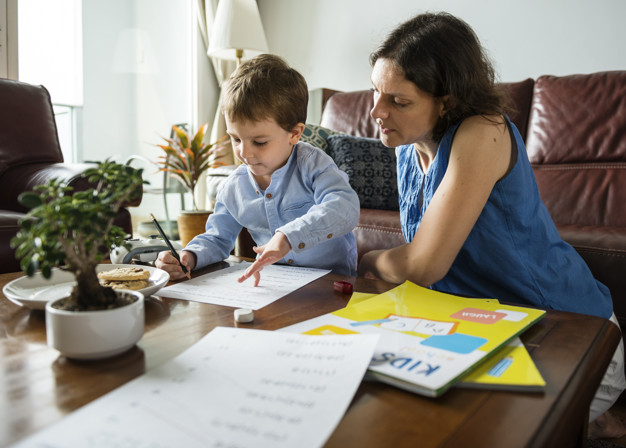 Mãe ensina o filho em casa, dentro da proposta educacional homeschooling.