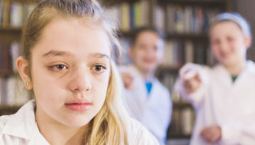 Crianças praticam cyberbullying e magoam colega de escola.