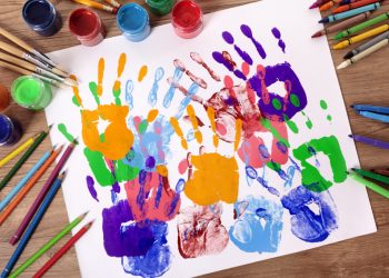 Mãos de criança pintadas em um projeto lúdico na educação infantil