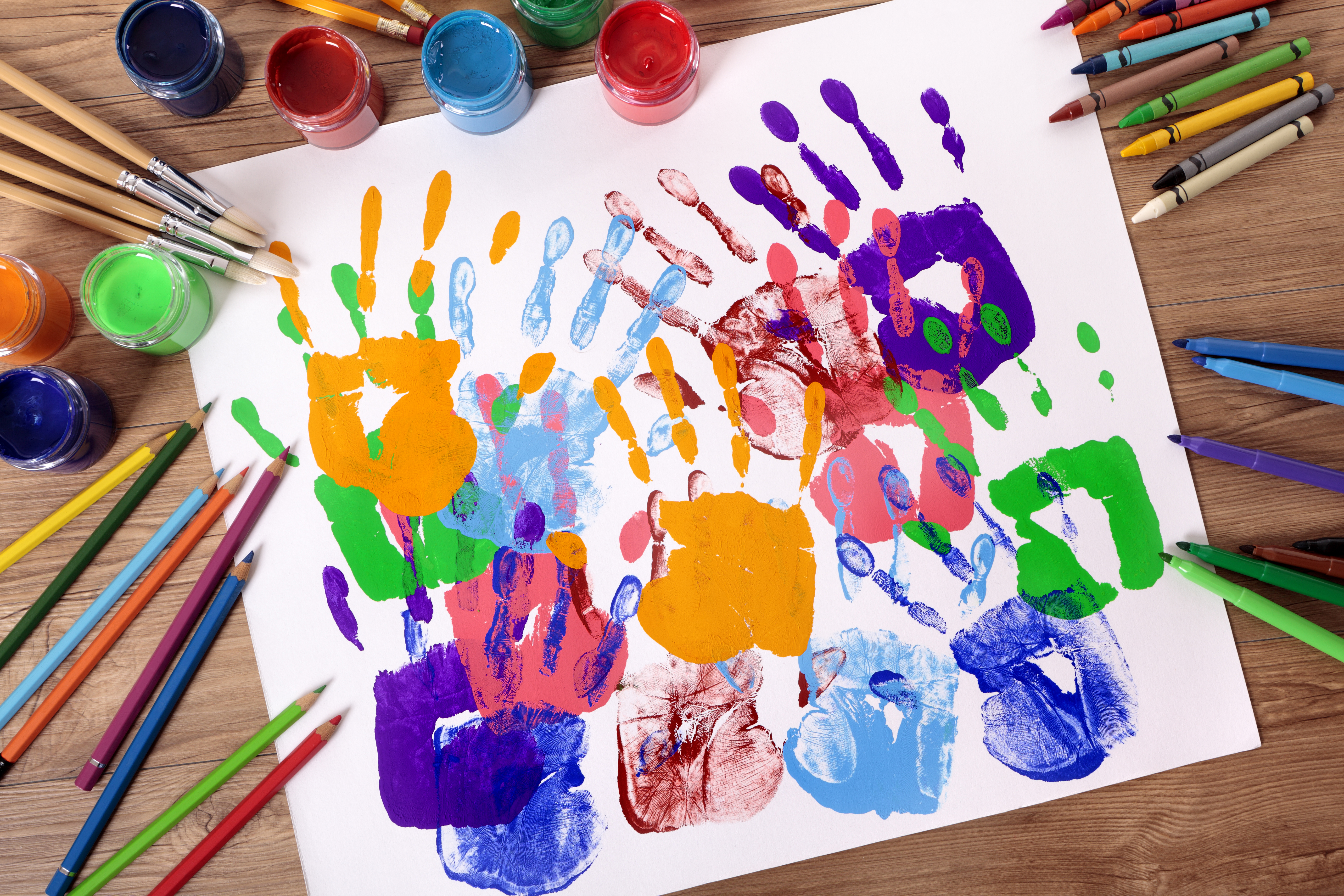 Mãos de criança pintadas em um projeto lúdico na educação infantil