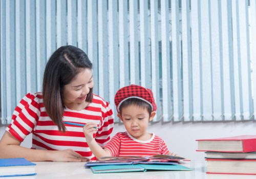 Mãe ajudando dever de casa do filho estimulando a família na escola