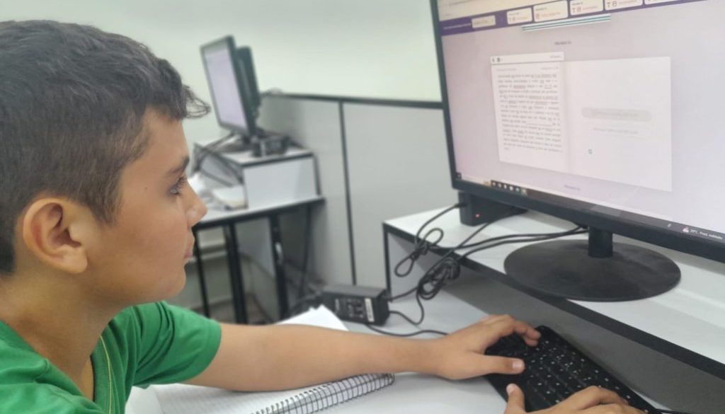 menino-em-frente-ao-computador-digitando-durante-aplicação-da-Estante-Mágica