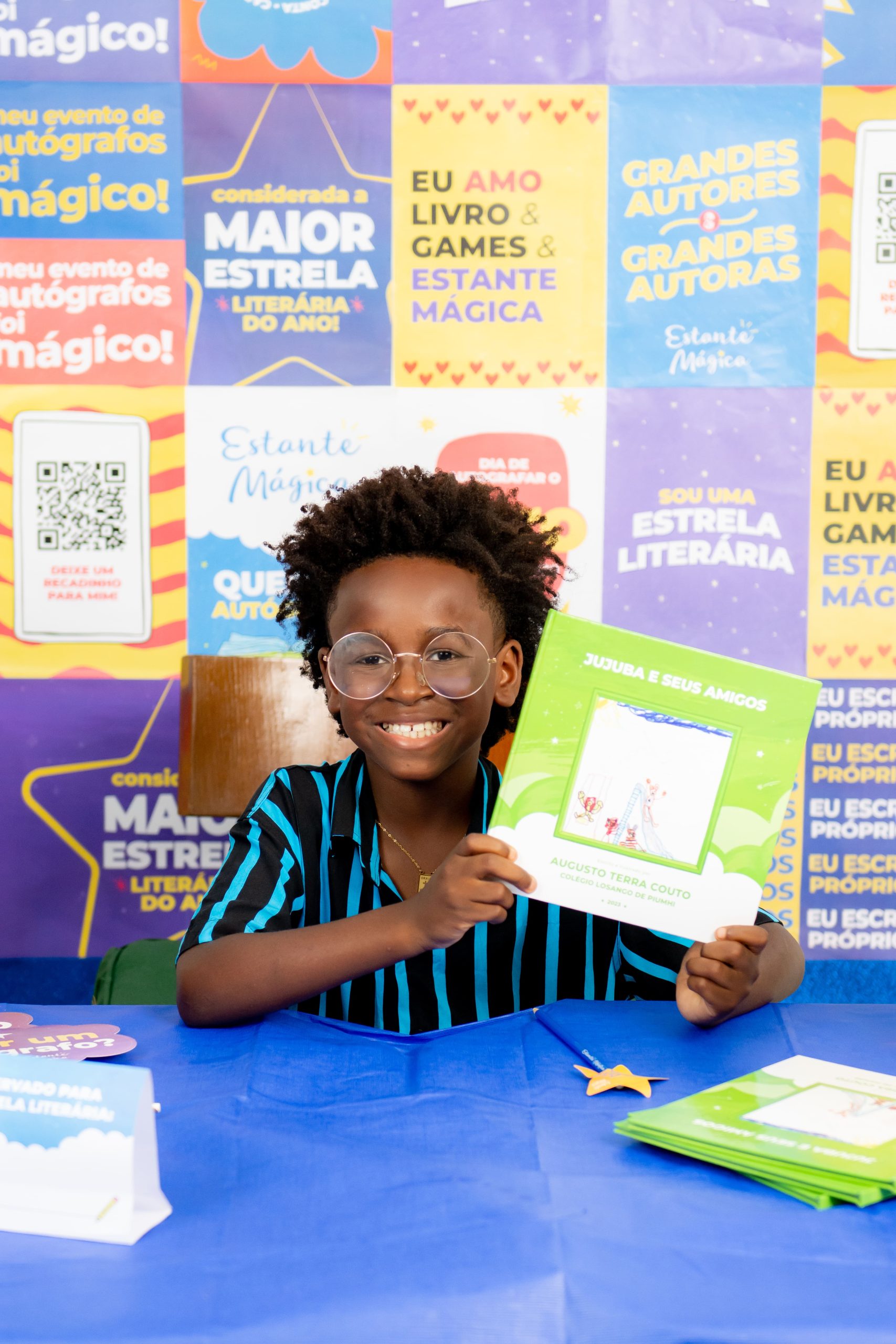 Criança com o próprio livro em um evento de autógrafos.
