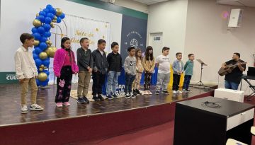 Crianças no palco em Evento de Autógrafos feito em parceria com a Estante Mágica.